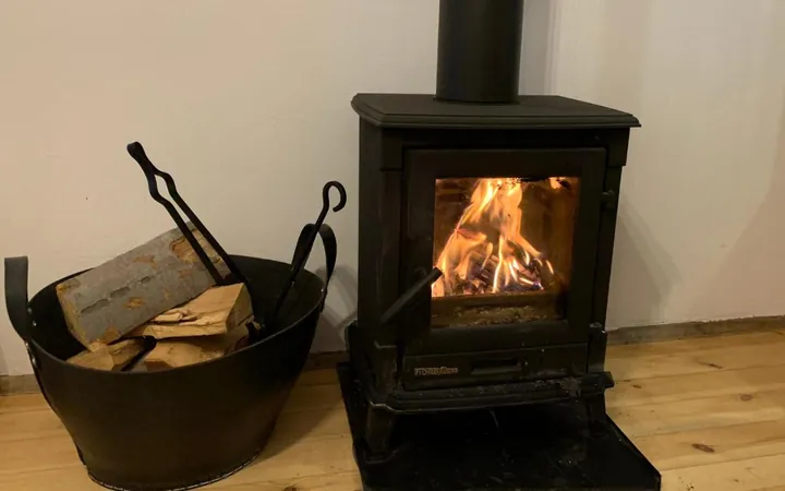 Black wood-burning stove with a basket of logs
