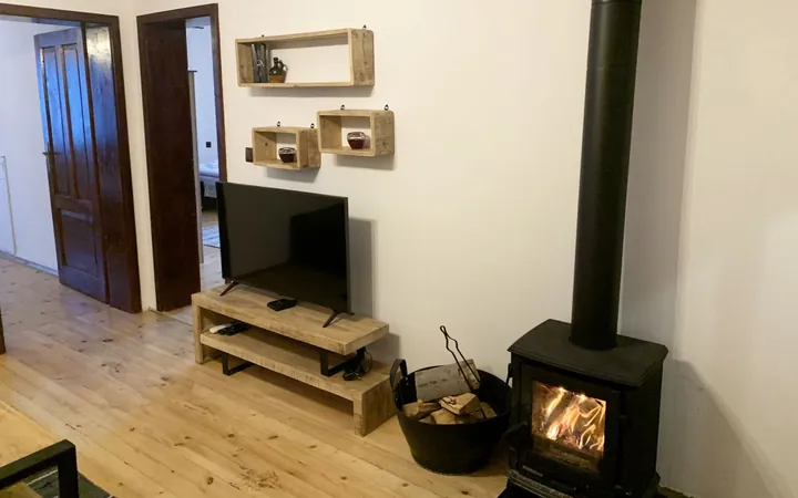 Wood stove beside the TV corner on a wooden floor