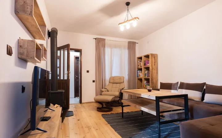 Living room with corner sofa, armchair and wood stove